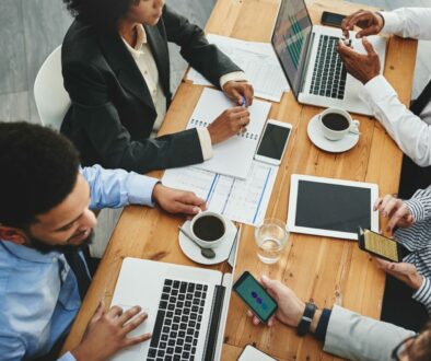Working from their multiple devices. Shot of a group of businesspeople having a meeting in an office.