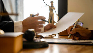 The Inflation Reduction Act: Healthcare, Business, and Other Provisions Close up of two tax professionals holding pens and tax law papers.